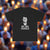 Black t-shirt with a graphic of a person and 'WE ARE CHARLIE' text on a white background