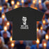 Black t-shirt with a graphic of a person and 'WE ARE CHARLIE' text on a white background