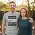 Man in Drunk Wives Matter shirt smiling next to frowning wife